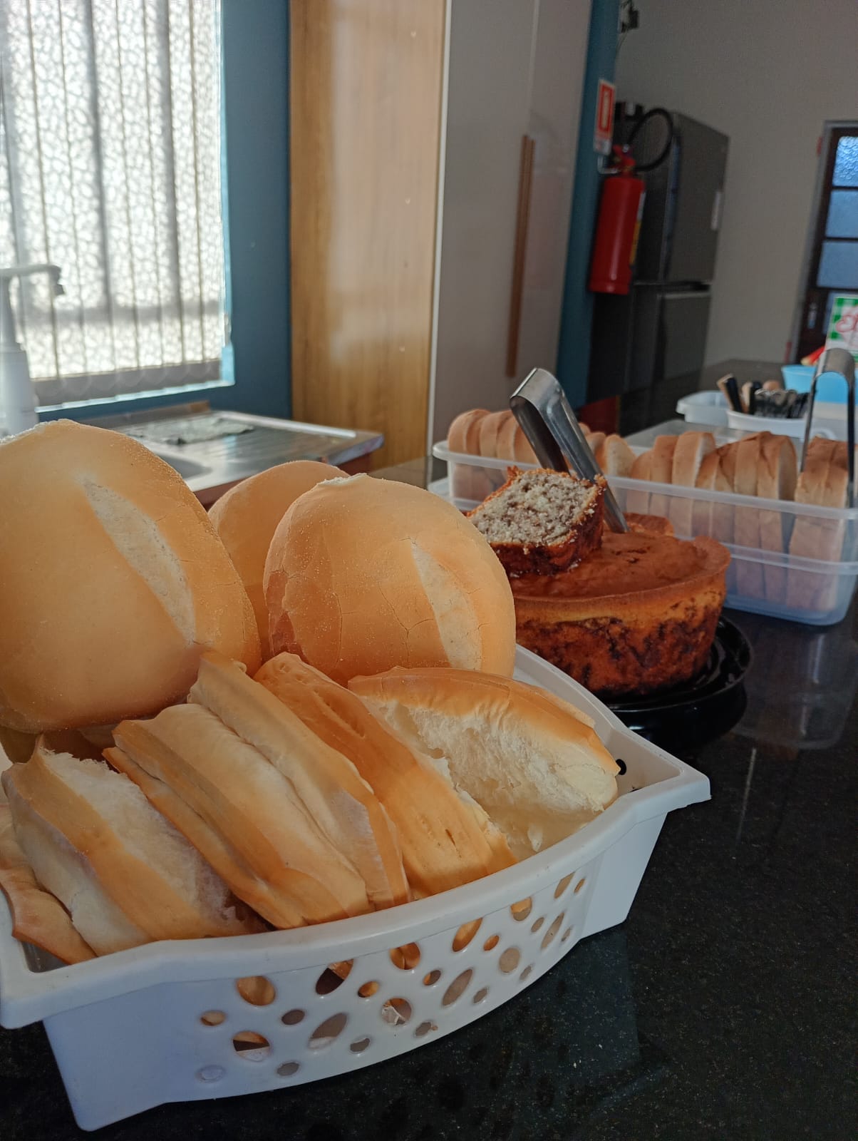 Mesa de café da manhã com pães frescos e bolo caseiro